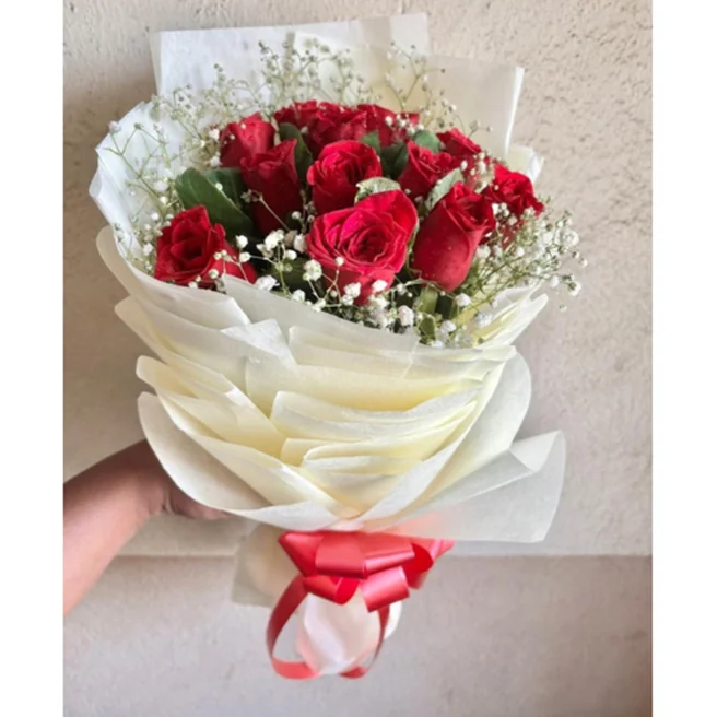 Romantic red roses bouquet with baby's breath wrapped in cream paper packing